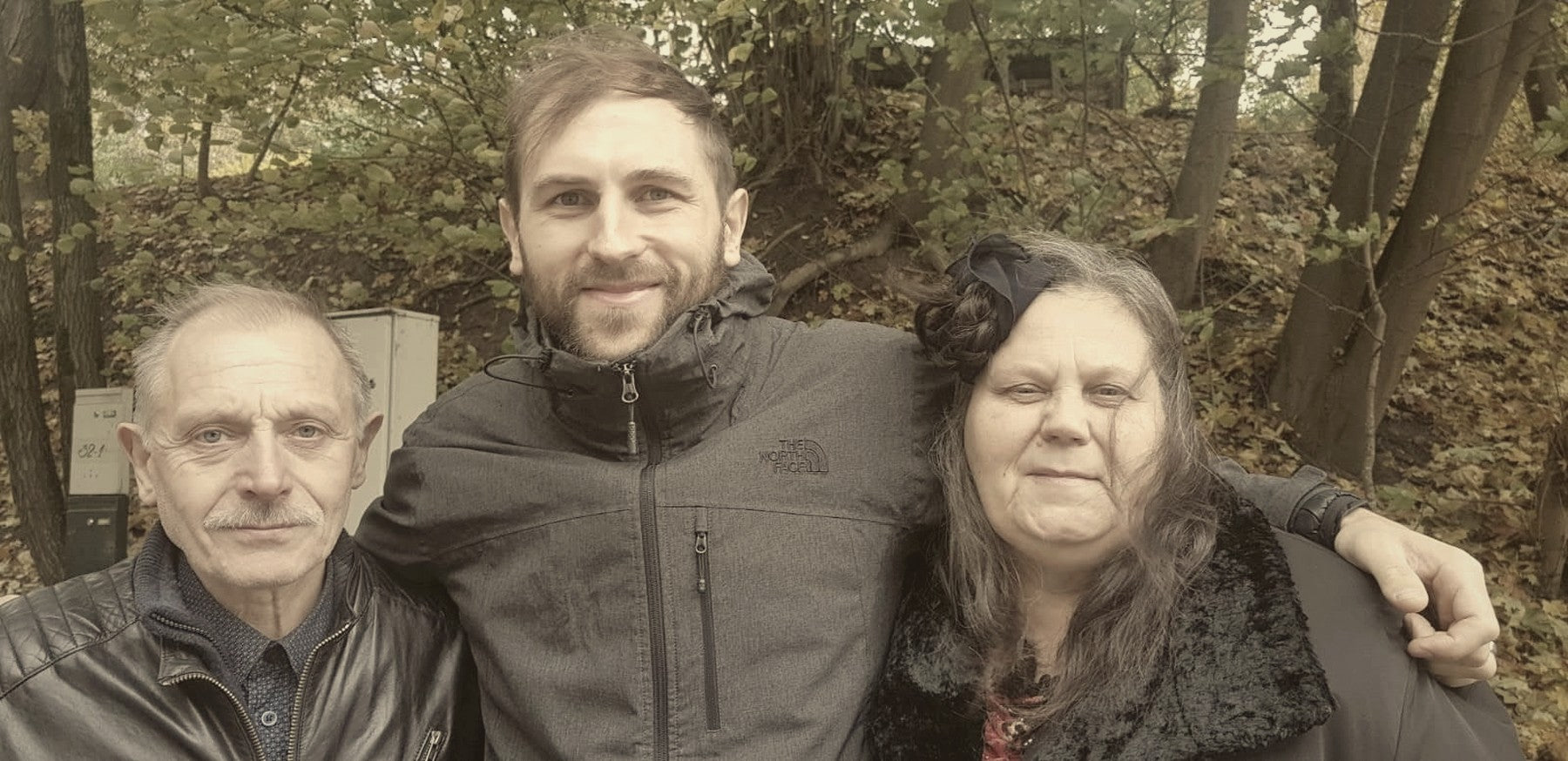 The founder of Mental Stack with his mother and father, photographed outdoors in autumn light.